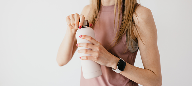 Glowing Skin Article - 02 woman with hydrated skin opening a water bottle